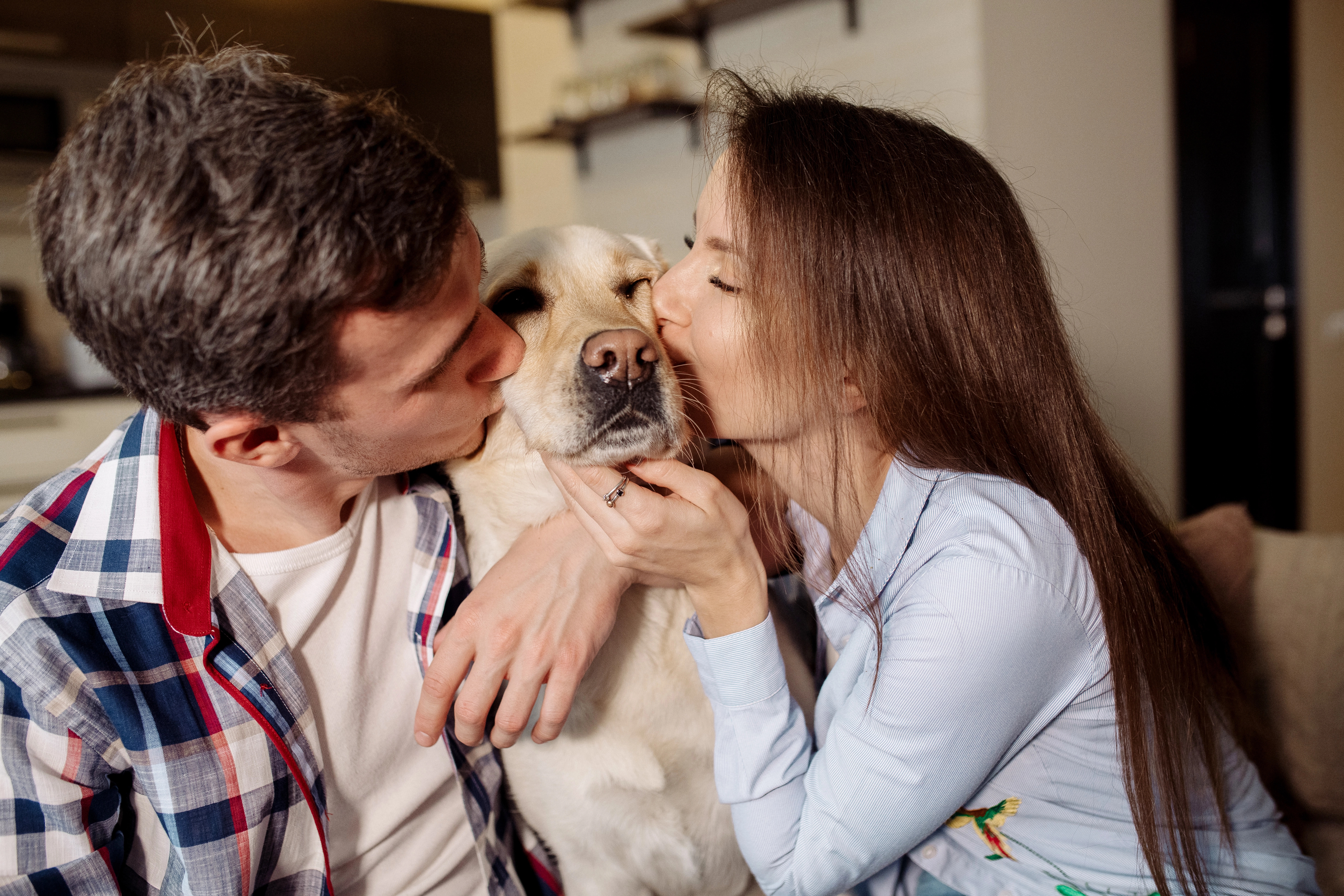 Couple kissing their dog